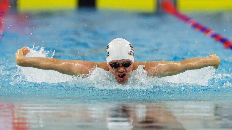 A man mid-breast stroke in a pool