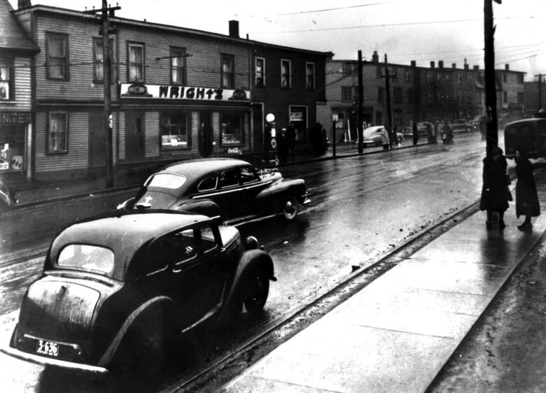 Cars travel the roadway in 1940's St. John's.