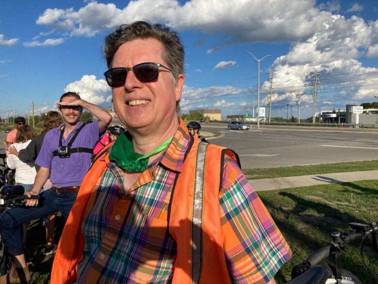 A man wearing sunglasses and a safety vest.