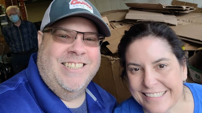 A man in a hat and a woman pose for a selfie.