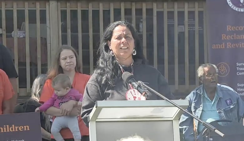 A woman standing in front of a podium.