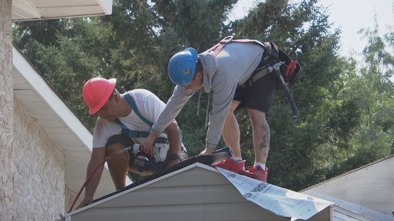 Two guys working on a roof.