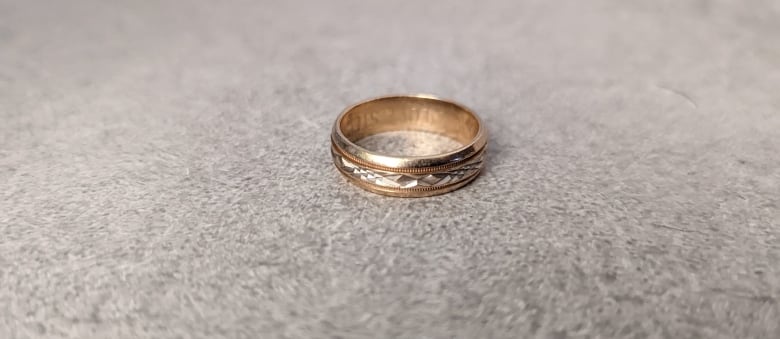 A silver wedding band with etchings on it.