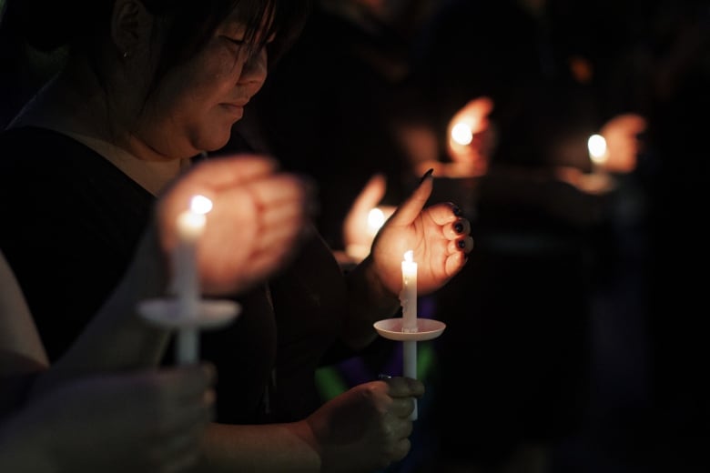 woman holding a candle at a vigil