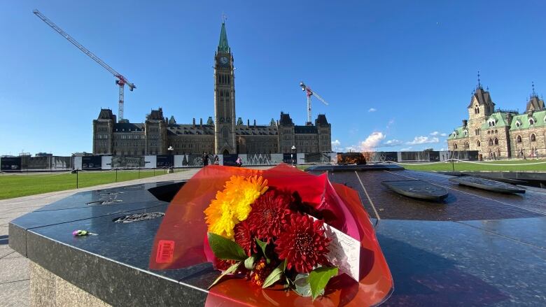 A bouquet of flowers lies on the rim of the Centennial Flame in Ottawa.