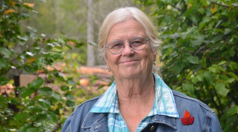 Retired nurse Patricia Baker stands in her leafy backyard near Sault Ste. Marie. 