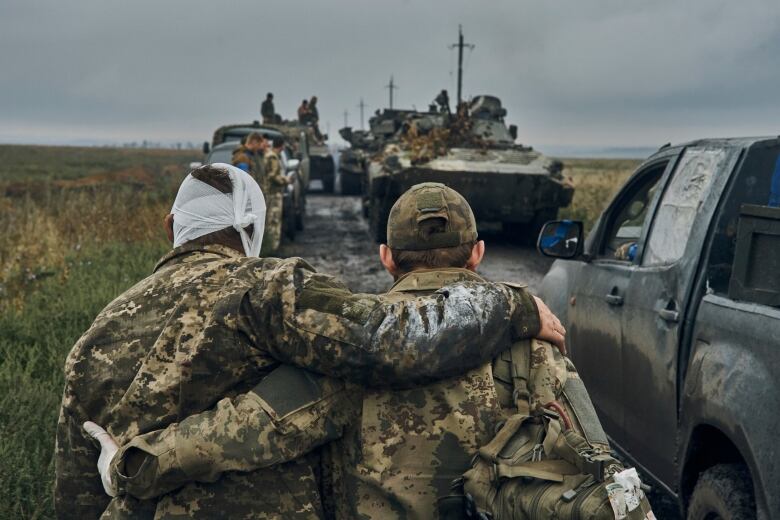 Two soldiers walk on a road