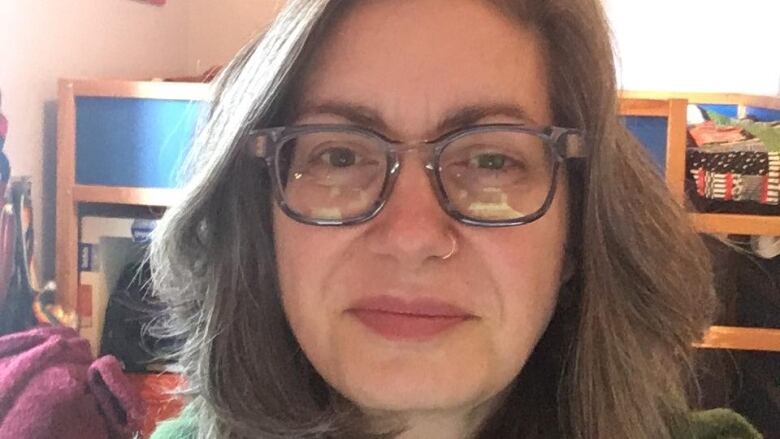 Close up of a woman with chin length hair, wearing glasses.