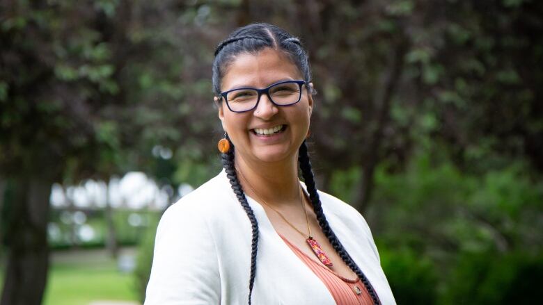 A woman wearing glasses smiles. 