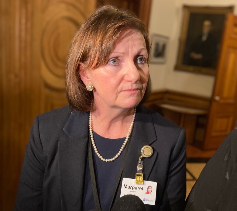 Microphones point at woman who looks at person off camera.