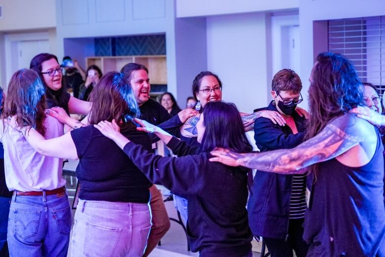 People conga line dance in a room.