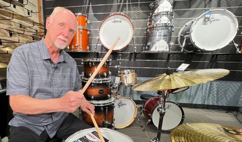 A man plays the drums.