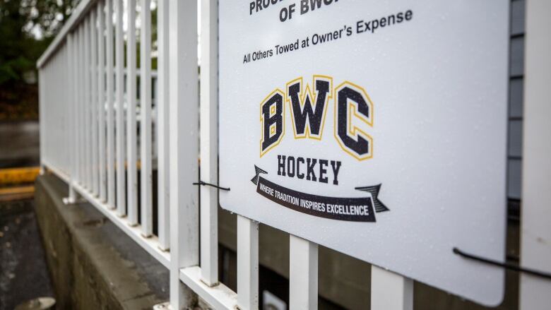 A sign that reads 'BWC Hockey: Where tradition inspires excellence' hung on a gate.