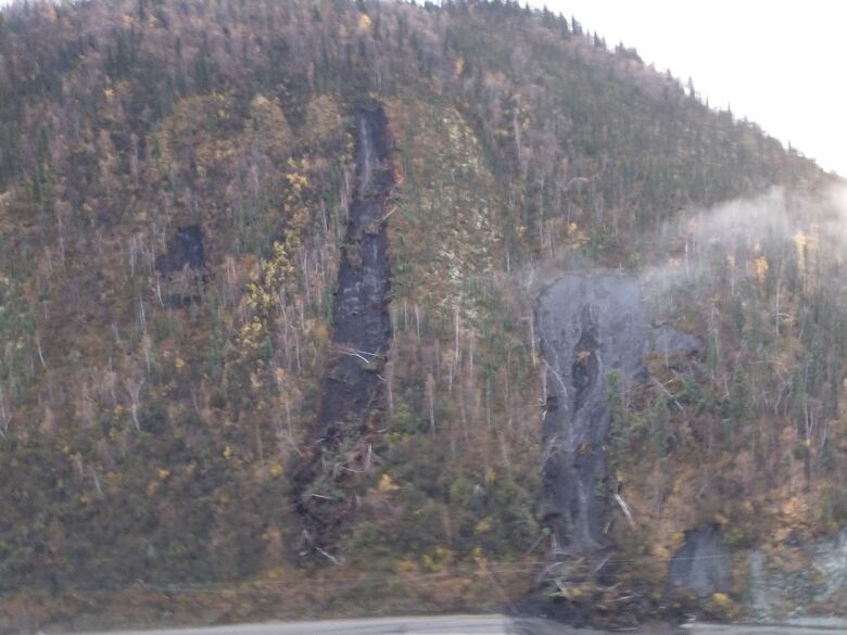 Tracks of earth are seen on the side of a mountain.