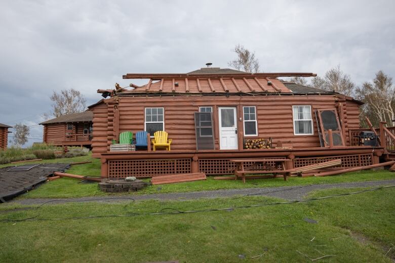 A wood cabin with roof damage