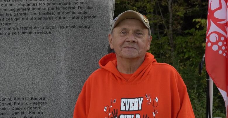 Decontie standing in front of the memorial for those who were forced to attend residential school from Kitigan Zibi. 