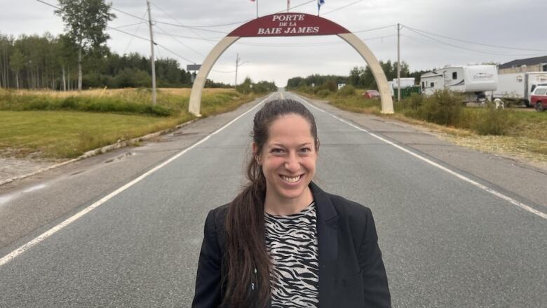 A portrait of a woman standing on a road.