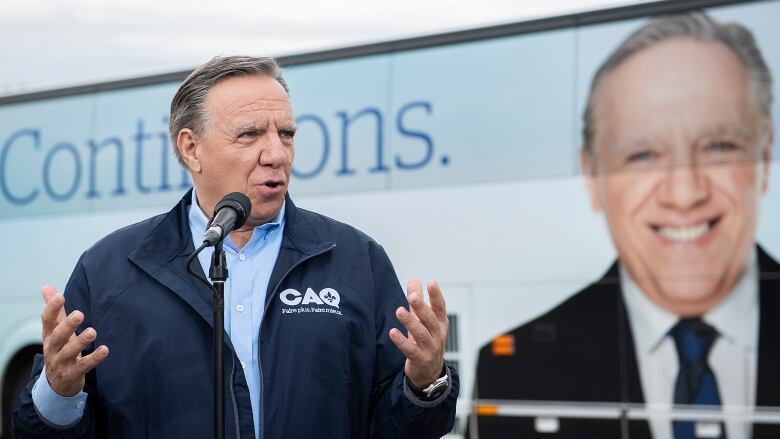 A man is standing in front of a bus