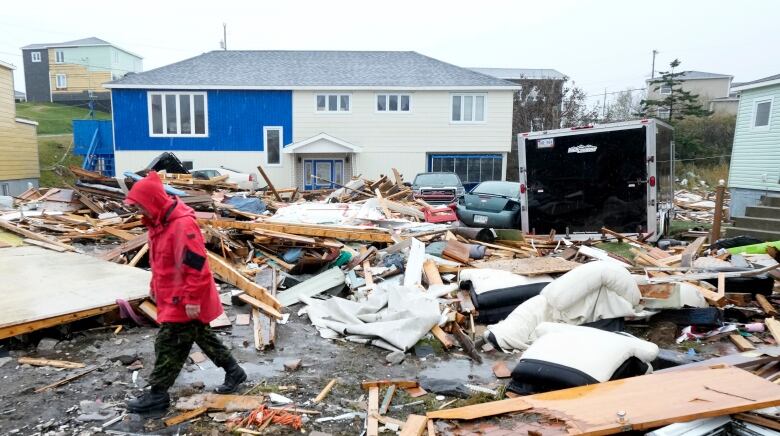 A Canadian Forces Ranger walks through the rubble of destroyed homes after post-tropical storm Fiona.