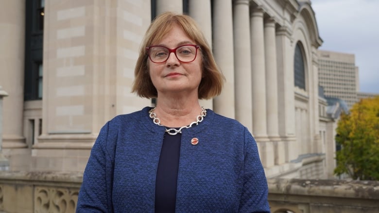 A politician poses outside of a Roman-style building.