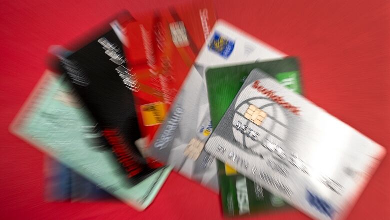 Credit cards are shown in a pile with blurring added to the image.