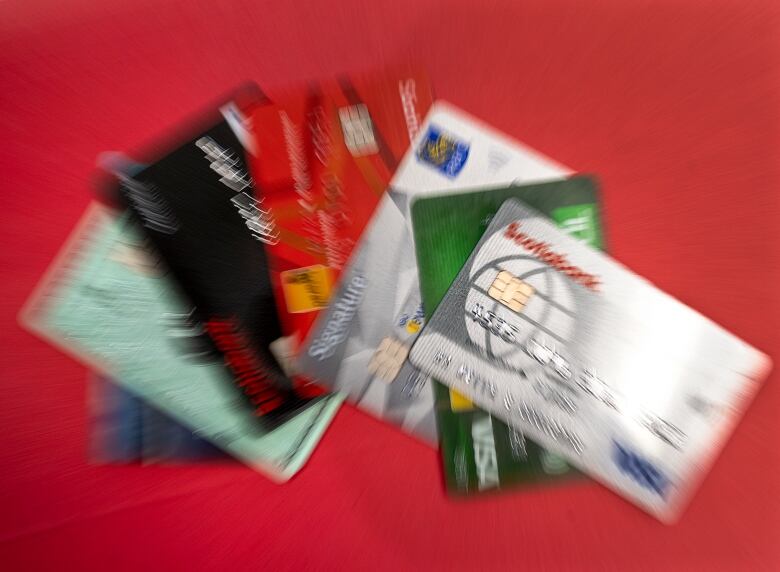 Credit cards are shown in a pile with blurring added to the image.