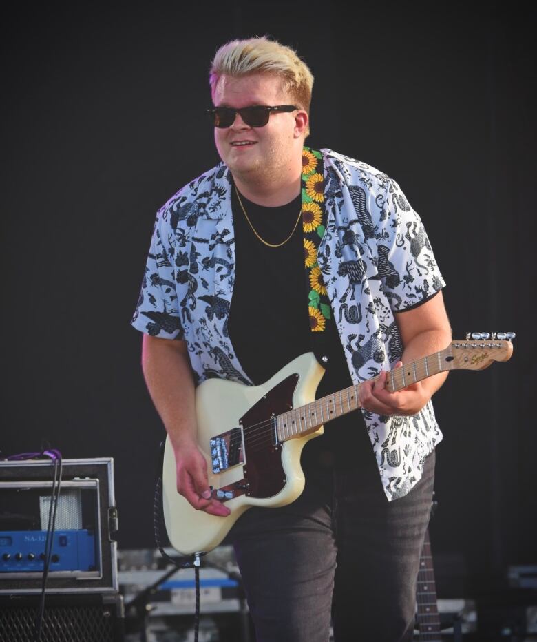 A young man with a guitar.