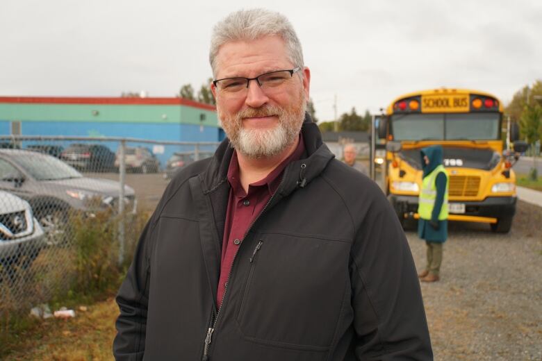 A close-up of Craig with a school bus in the background.