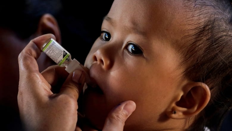 A child receives free oral polio vaccine.