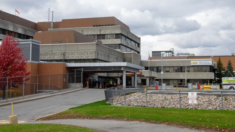 Paramedics take someone inside a hospital door.