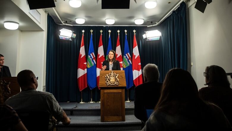 A woman stands behind a podium.