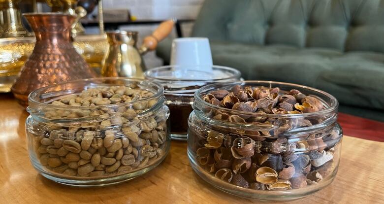 Coffee beans, shells and grounds sit in three glass jars on a table in 3Cents cafe and resto. 