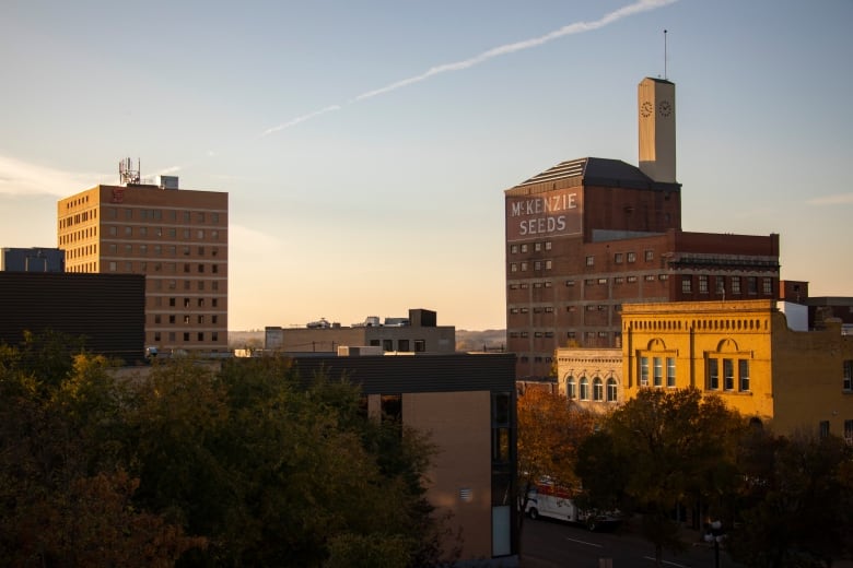 The sunsets on a the skyline of a downtown buildings.