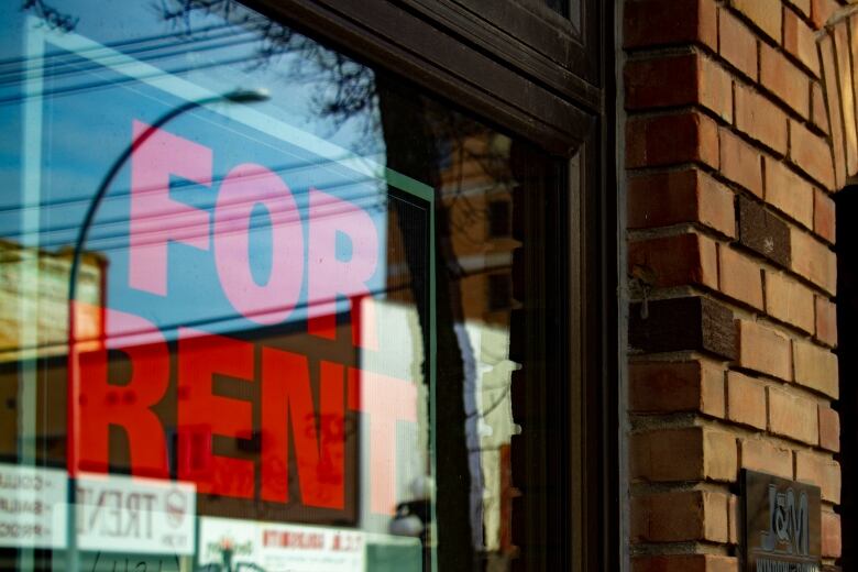 A for rent sign is taped to a window.