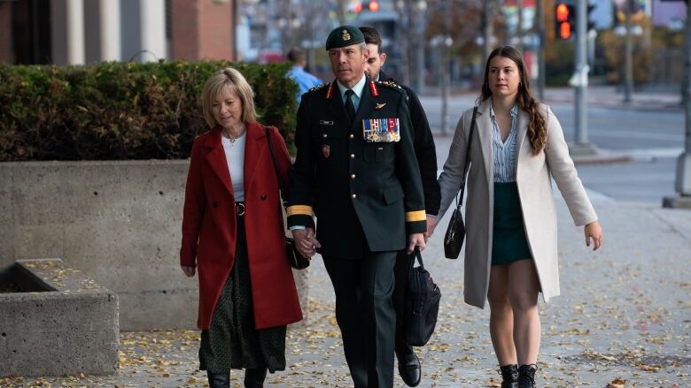 Photo of major general dany fortin walking into Quebec court with his wife and daughter during his criminal trial last year.