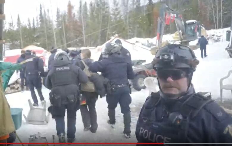 Uniformed RCMP officers arrest people. 