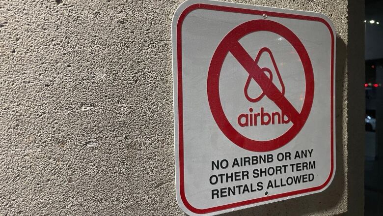 A sign with an AirBNB logo with a slash through it.