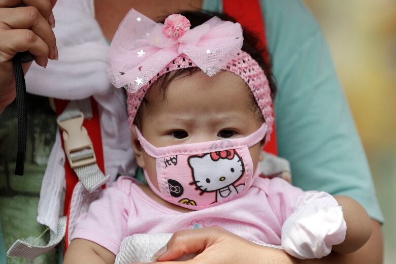 A baby wears a protective mask in Manila, Philippines.