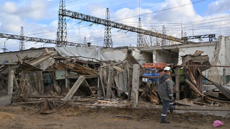 A worker examines destructions as he repairs equipments of power lines destroyed after a missile strike on a power plant.