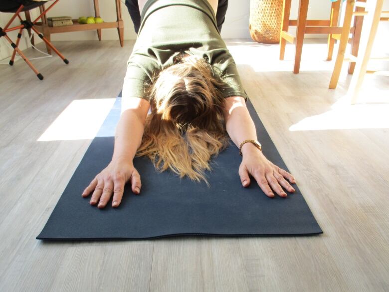 A woman does yoga in front of the camera