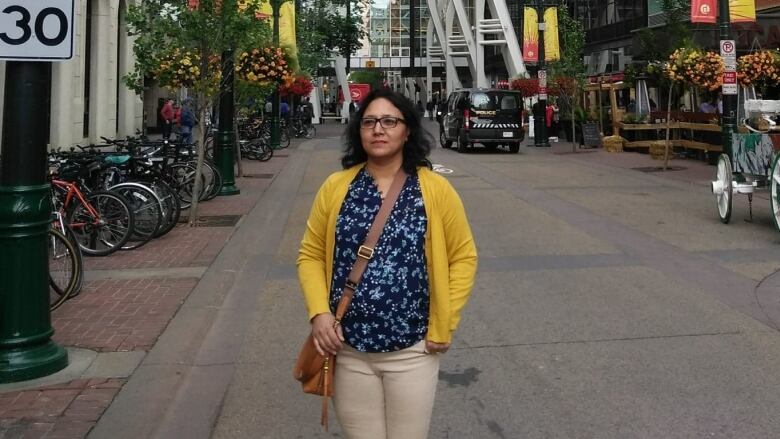 A woman stands on a street.