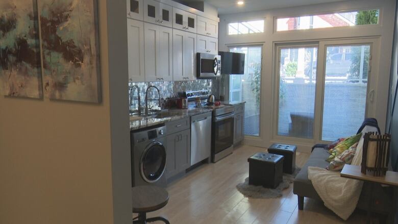 A small apartment with kitchen cupboards and a futon.