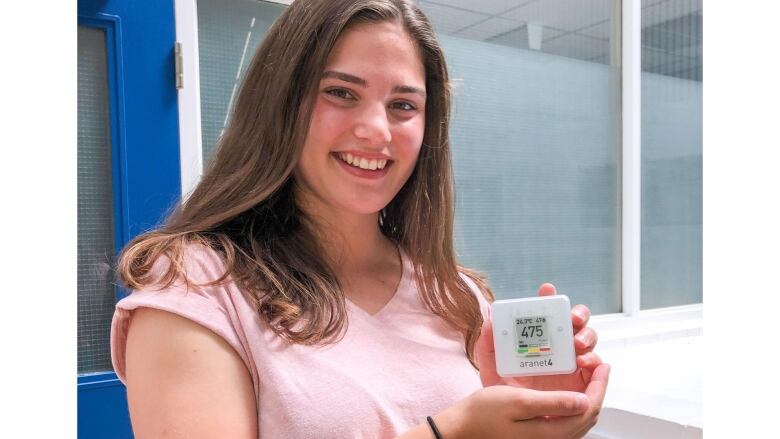 A woman holding a carbon dioxide monitor.