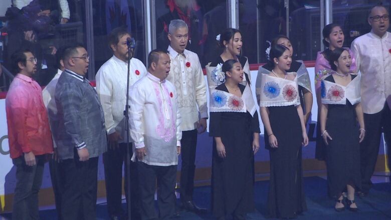 A Filipino choir sings on the ice at Canada Life Centre.