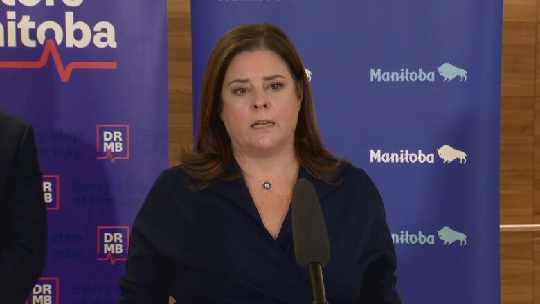 A woman speaks into a microphone at a podium