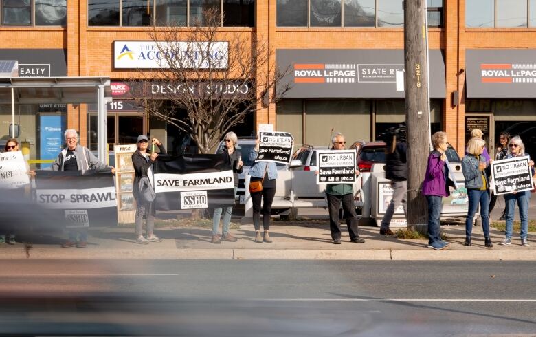 A crowd of people standing, clapping and holding signs.