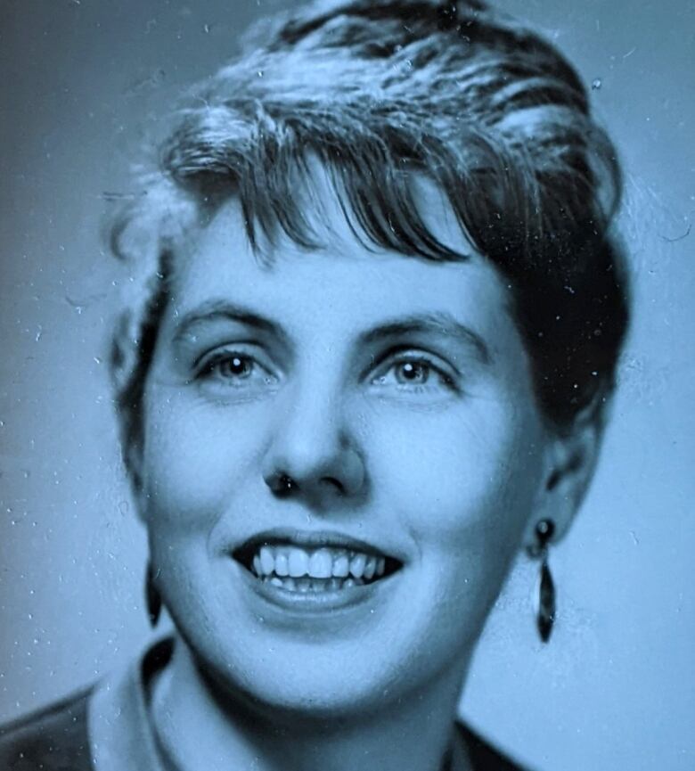 A black-and-white photo of a young woman, smiling and looking slightly off camera.