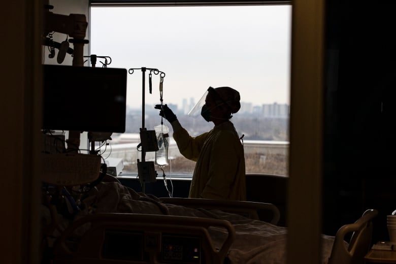 A nurse attends to a COVID-19 positive patient in the Humber River Hospital intensive care unit on Jan. 13, 2022.