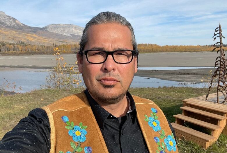 A man stands in front of a river