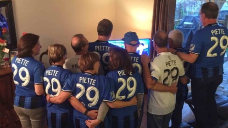 A group of people wear CF Montreal jerseys with the last name 